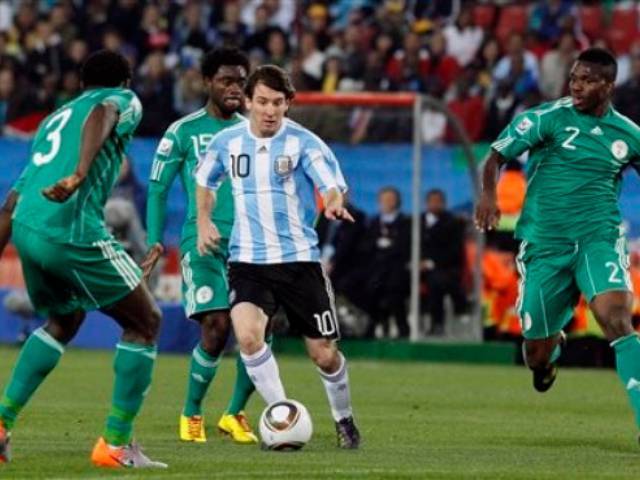 Argentina's Lionel Messi, center, controls the ball as Nigeria's Taiwo, Haruna and Yobo